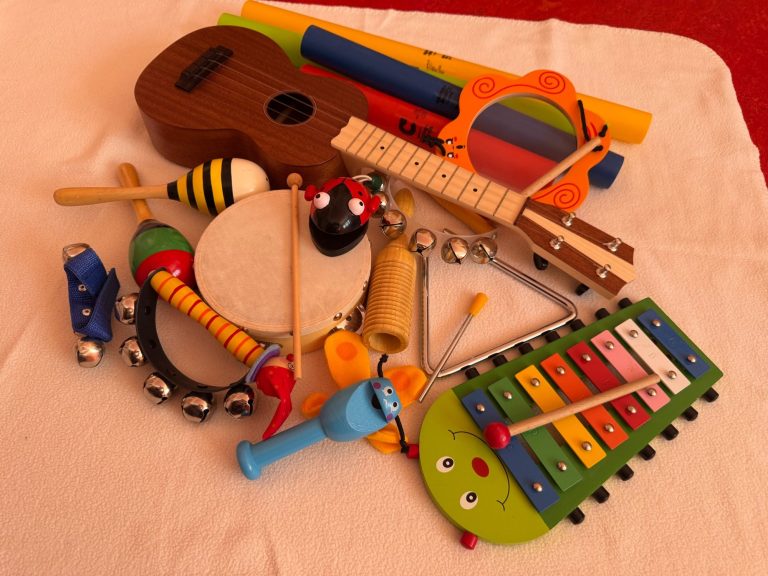 Kreativ und Musik Bunte Musikinstrumente, darunter eine Ukulele, Tamburin und Xylophon.